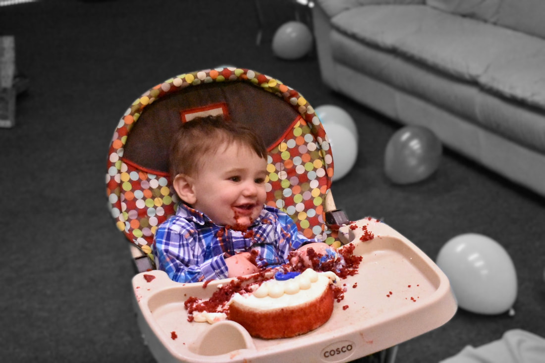 Photo of a little boy eating his 1st birthday smash cake